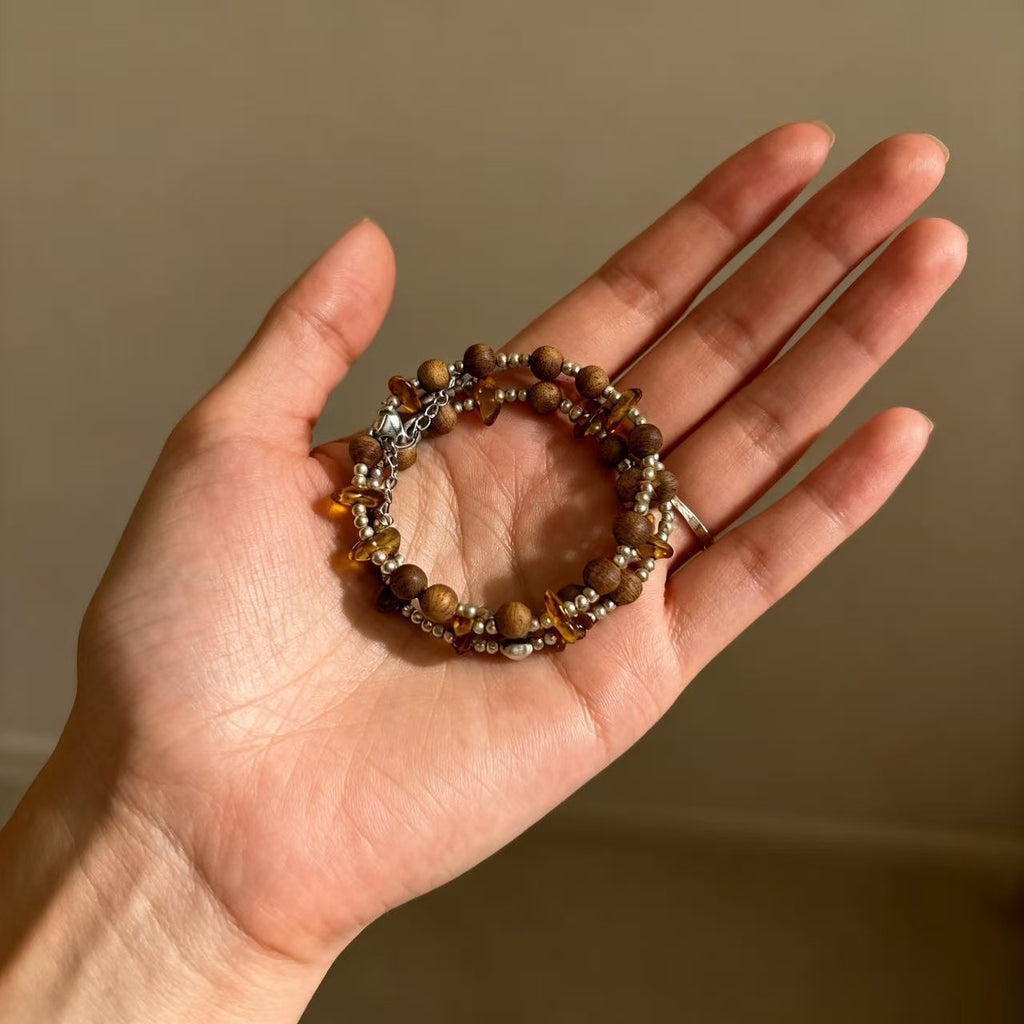 A delicate harmony of natural agarwood and warm amber-inspired stone accents.